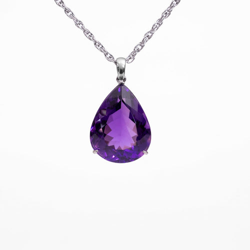 A teardrop-shaped purple Amethyst gemstone pendant necklace in a silver setting on a delicate silver chain, shown against a plain white background.
